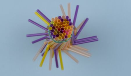 colorful straws for summer cocktails on light blue background with copy space. Top view. Drinking...