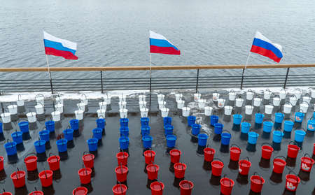 Russia, Krasnoyarsk, March 2020: many colorful plastic buckets. water for dousing a person, a...