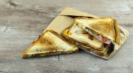 hot sandwiches for breakfast on a wooden table. concept of cooking fast and delicious foodの写真素材