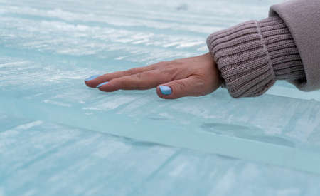 the hand is on the ice. smooth ice blocks sawn to create decorations.の写真素材