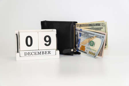 calendar and wallet with money. Handmade wood cube with date month and day. financial and tax...