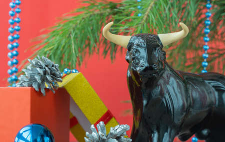 Festive Christmas decorations on a red background. bull as a symbol of the new year 2021. xmas beadsの写真素材