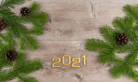 green Christmas tree on a wooden vintage background. fir branches with cones. new year 2021. copy...