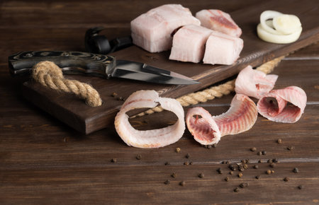 sliced frozen fish. selective focus. raw frozen fish cut into shavings on a wooden background. one...