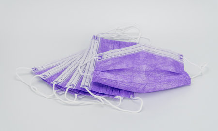 disposable mask in purple on a white background. antiviral medical mask for protection against  virus. Glamorous Surgical protective mask. Lockdown. national mask mandateの写真素材
