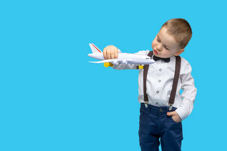 boy holds a toy airplane in his hand. the child dreams of becoming a pilot. young Aviator. kid wants...