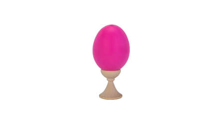 pink easter egg on a wooden stand, white background. attribute of the celebration of the oldest Christian holiday of Easter.の写真素材