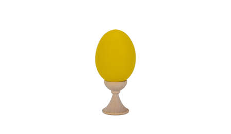 yellow easter egg on a wooden stand, white background. attribute of the celebration of the oldest Christian holiday of Easter. set of bright bollocksの写真素材