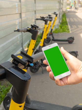 smartphone screen and electric scooter. Rent an street transport by scanning QR code. Payment for...