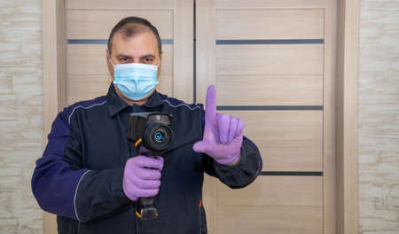 person measures the temperature with a thermal imager. mask mode and temperature control