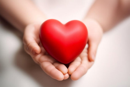 child's hand gently holds a heart, radiating innocence and loveの素材