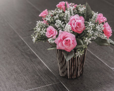 Plastic rose flower on wood cottonの写真素材