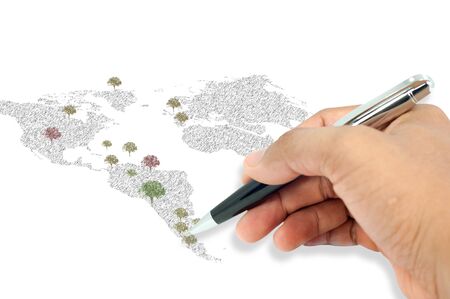 Hand holding a pen, drawing  tree and world map on white の写真素材