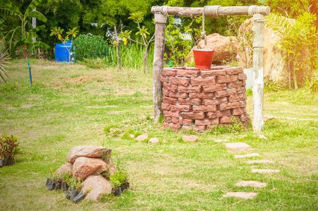 New water well with metal bucket in park with red bucket , Selective focus at brick of water wellの写真素材