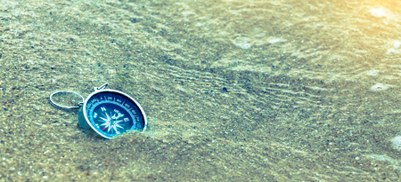 Retro style of tourist compass on the sand beach
