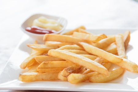 French fries in a bowl on a wooden backgroundの写真素材