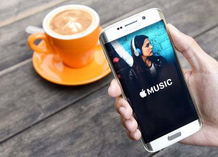 CHIANG MAI, THAILAND - NOV 20, 2015: A man hand holding screen shot of Apple music app showing on samsung galaxy s6 edge.のeditorial素材