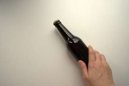 Image from above of a hand holding a beer bottleの写真素材