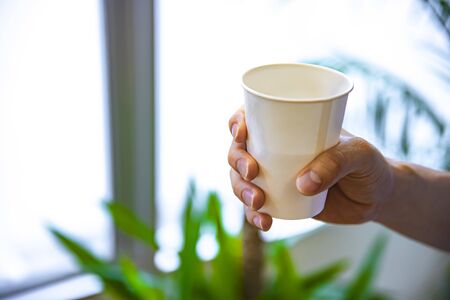 A cup of tea with right hand in the office