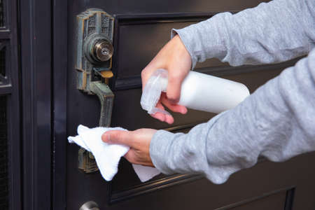 Disinfecting door knob by cleaner at the entrance