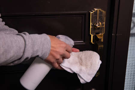 Disinfecting door knob by cleaner at the entranceの写真素材