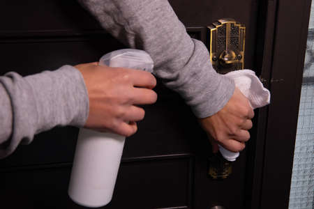 Disinfecting door knob by cleaner at the entrance