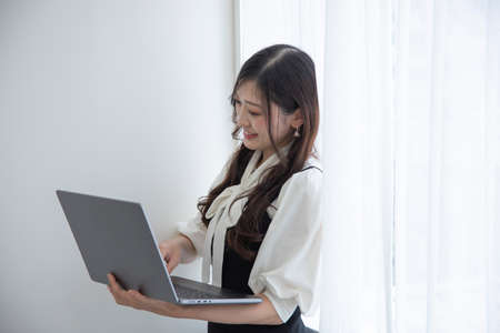 A working Japanese woman by remote work in the home office closeupの写真素材
