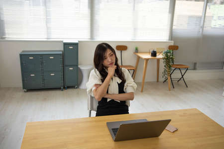 A worried Japanese woman by remote work in the small office