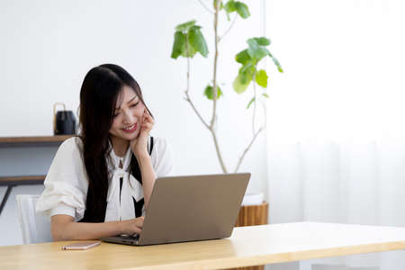 A working Japanese woman by remote work in the home office closeupの写真素材
