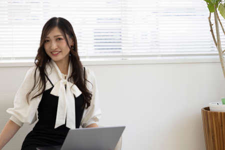 A working Japanese woman by remote work in the home office closeup