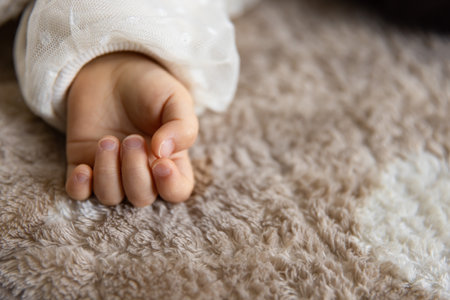 A left hand of sleeping asian baby on the carpetの写真素材
