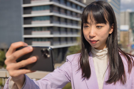 A portrait of selfie by Japanese woman behind cherry blossom bust shot