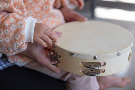 Childs hands with tambourine in the living room closeupの写真素材