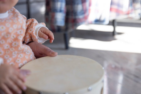 Childs hands with tambourine in the living room closeupの写真素材
