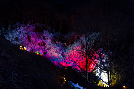 A landscape of colorfully illuminated icicles at nightの写真素材