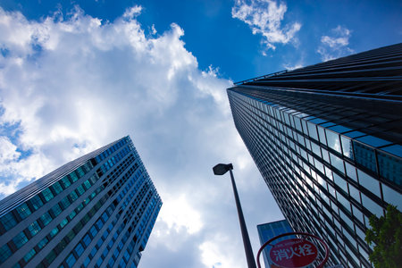 A cityscape of moving cloud reflecting the office building at the business townの写真素材