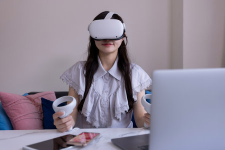 A Japanese woman wearing VR glass in front of PC and tablet in the room
