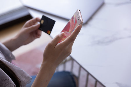 Hands of woman online shopping by card and smartphone in the living roomの写真素材