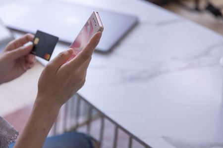 Hands of woman online shopping by card and smartphone in the living roomの写真素材