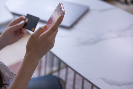 Hands of woman online shopping by card and smartphone in the living roomの写真素材