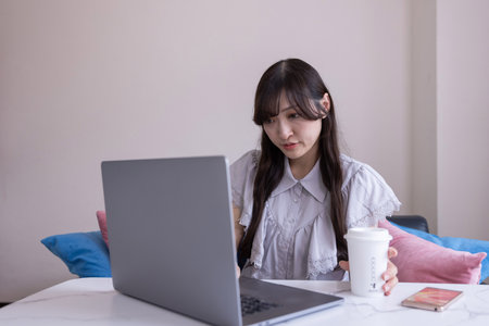 A Japanese woman working by laptop in the living room