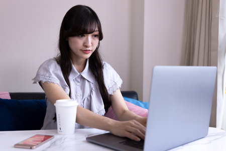 A Japanese woman working by laptop in the living room