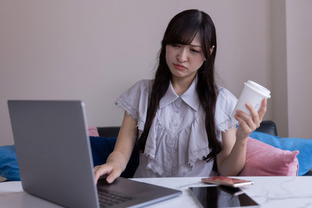 A Japanese woman worried with laptop in the living room during work