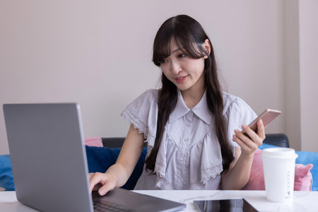 A Japanese woman working by laptop in the living room
