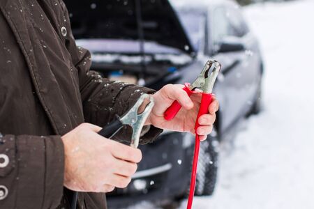 car, winter, people and vehicle concept - closeup of man pushing car stuck in snow