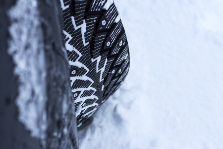 car, winter, people and vehicle concept - close-up of a car wheel in the snowの写真素材