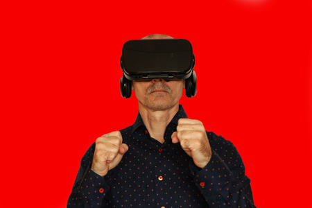 Close-up of a man in a black T-shirt with glasses of virtual reality. The background is white.