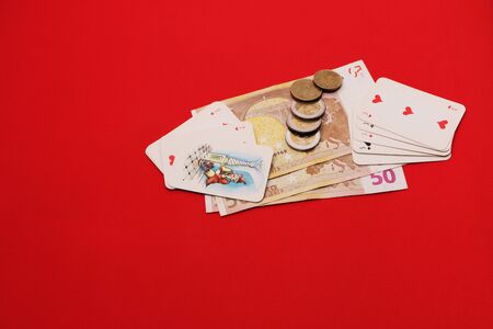 In the casino on the gaming table are cards and money. The background is red.の写真素材