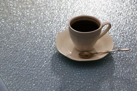 A cup of coffee in the evening on the table. Darkened background. Background in the form of drops of water in red and blue.の写真素材