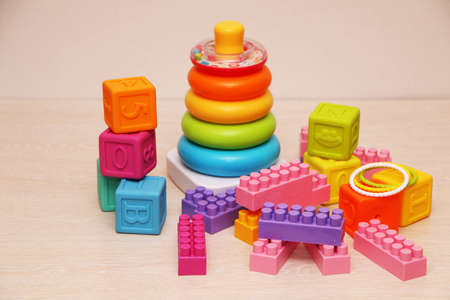 Children's toys, colorful plastic bricks at the table. Children's pyramid of rings and bright...